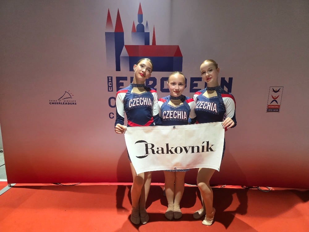 Členky oddílu cheerleadingu s praporem Rakovníka